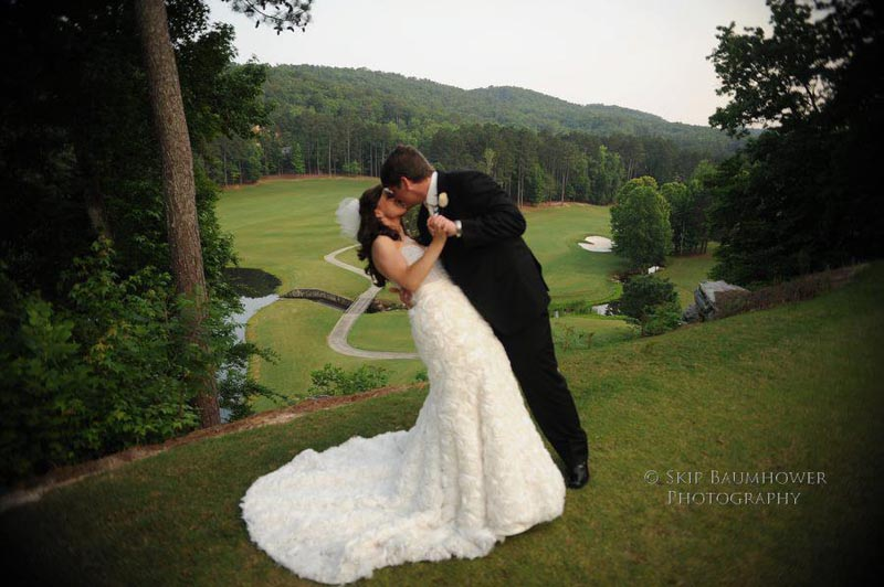 A groom and bride kissing on golf course