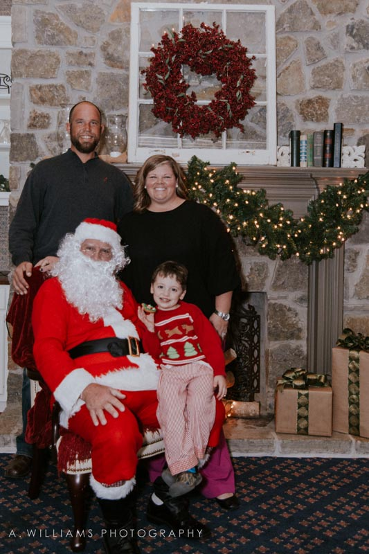 Parents posing with their child and Santa.